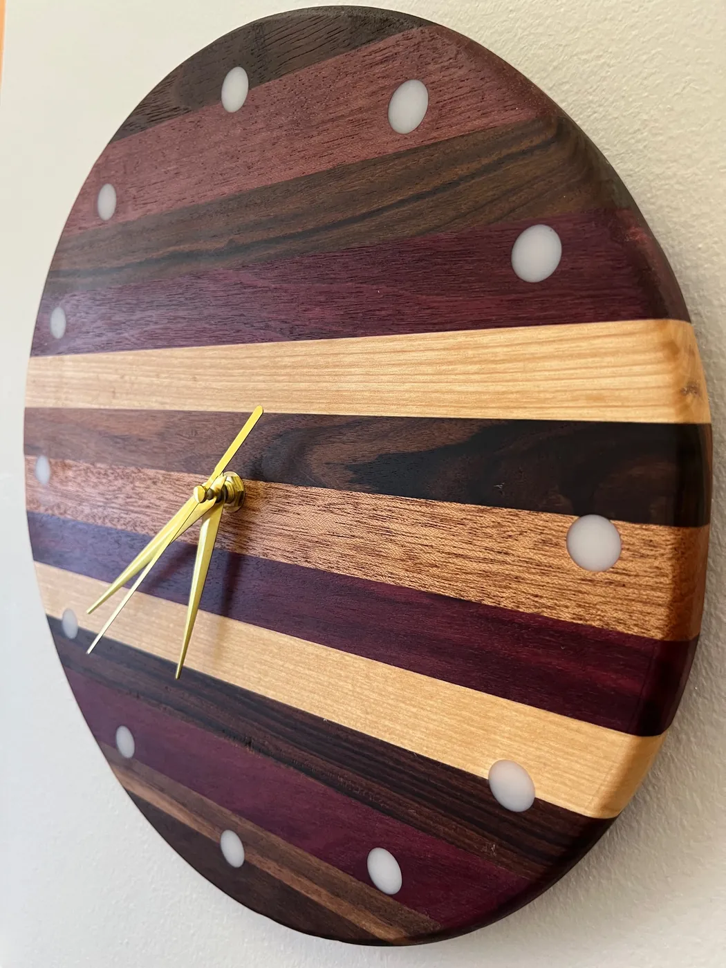 Close-up of a striped wood clock face with gold hands