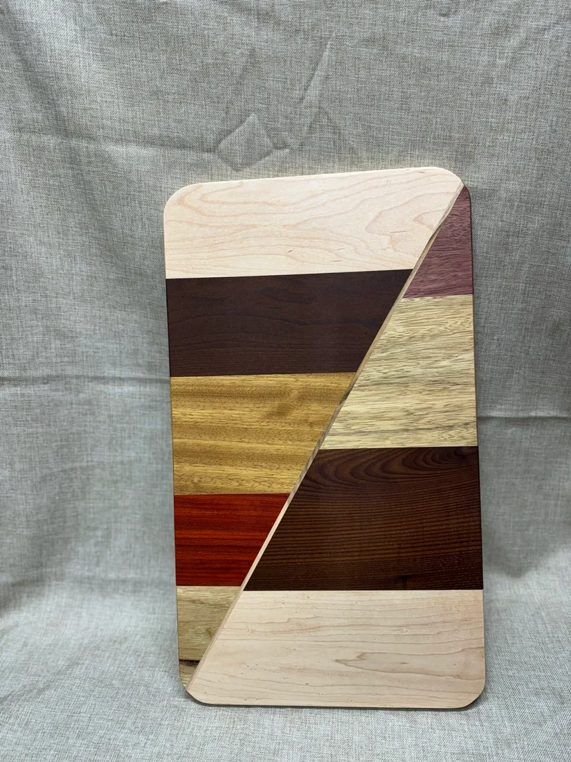 Tall charcuterie board with alternating hardwood strips and handle opening