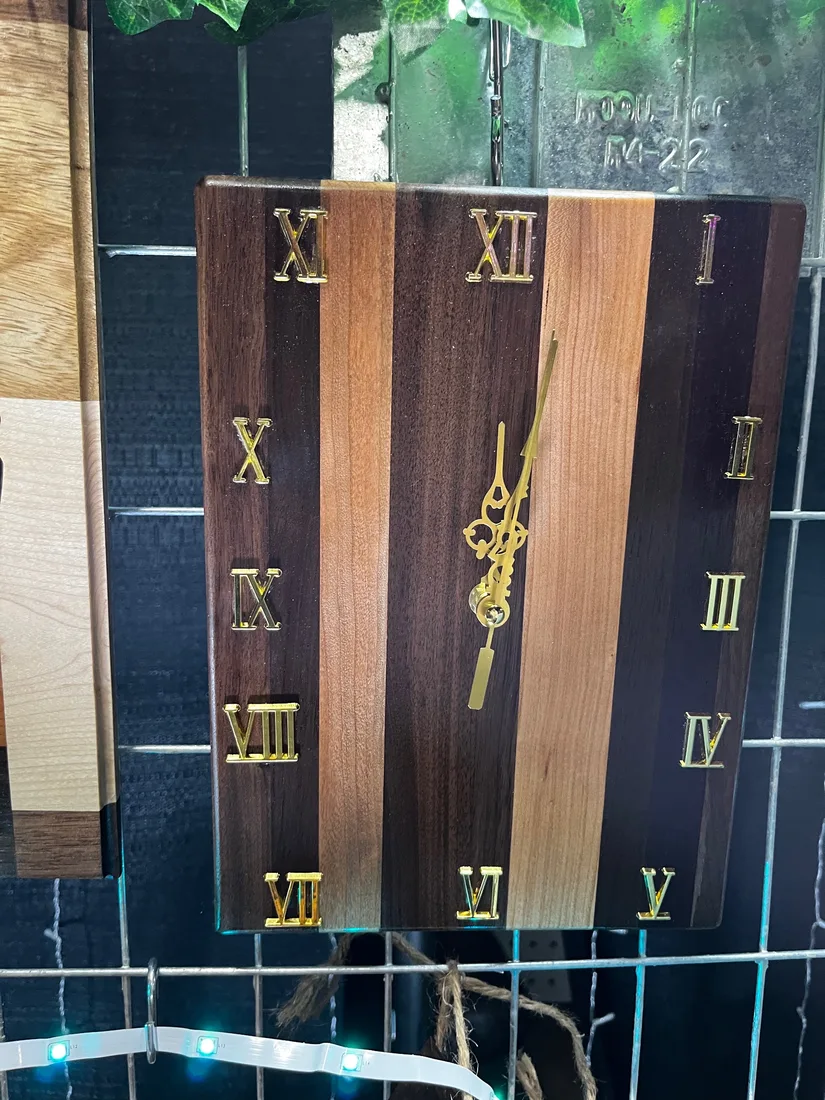 Two round wooden clocks with Roman numerals on display
